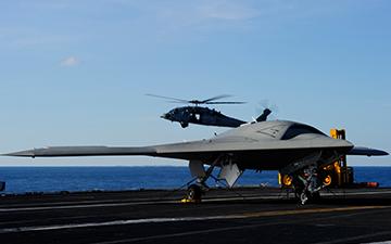 Fighter jet on the runway of a ship at sea and a helicopter flying in the background